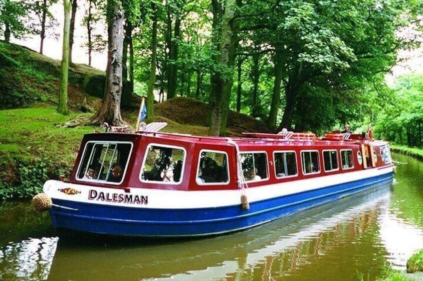 A red and blue boat named 'DALESMAN' on a river surrounded by trees. 3