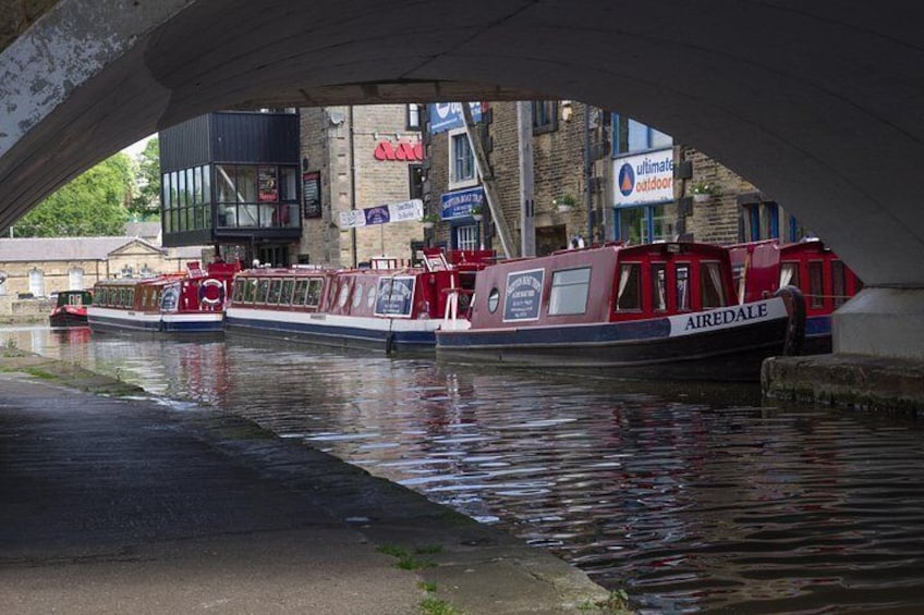 A canal with boats, a bridge, and buildings with signs. 2