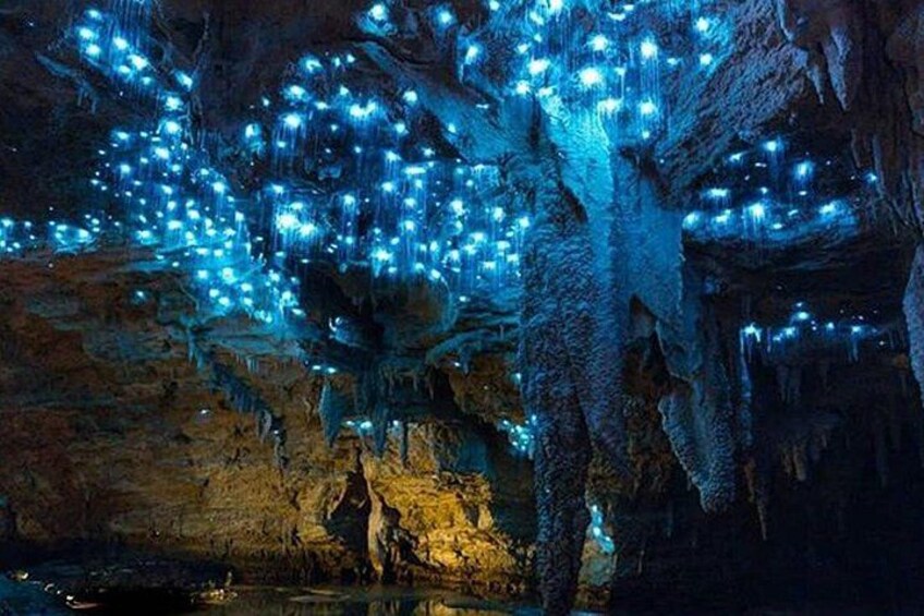 A cave illuminated with blue lights, stalactites, and stalagmites. 2