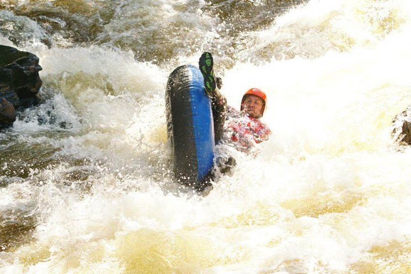 A person in a blue raft navigating through a turbulent river. 3