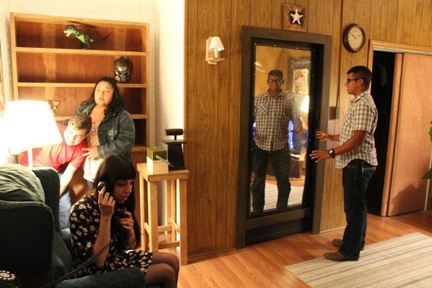 A living room with a wooden floor, a sofa, a lamp, a mirror, and a door. 4