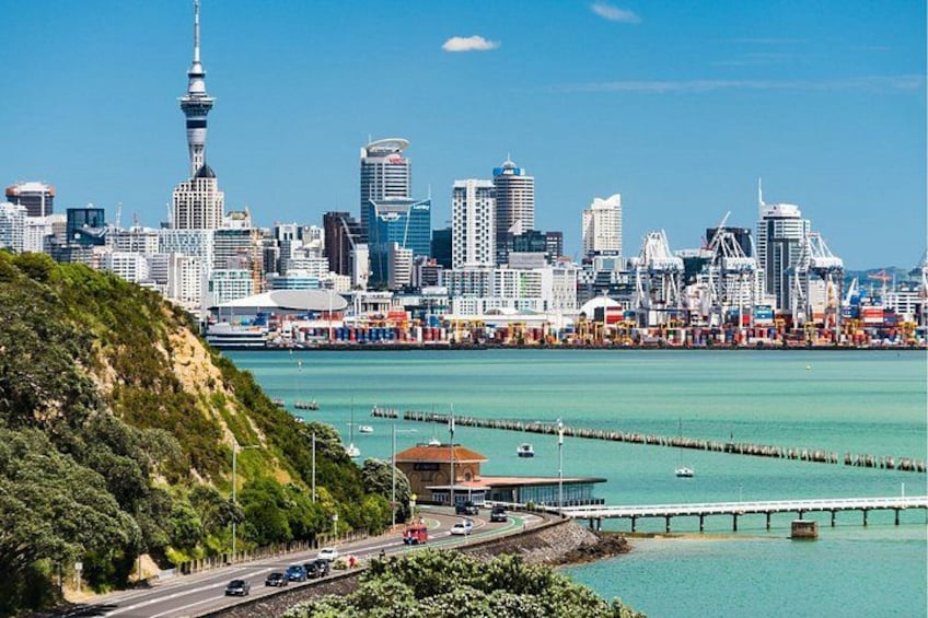 A city skyline with a prominent tower, a waterfront with a pier, and a hilly landscape. 3