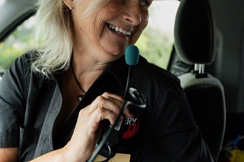 A person wearing a black shirt with a red logo, holding a microphone. 3