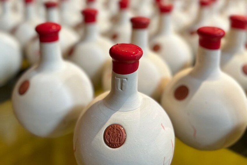 A row of white bottles with red caps and a letter 'T' on them. 3