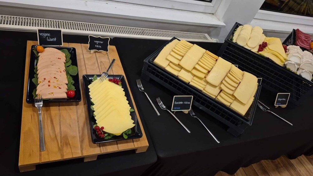 A buffet with various vegan and vegetarian dishes, including sliced meats, cheeses, and fruits. 5