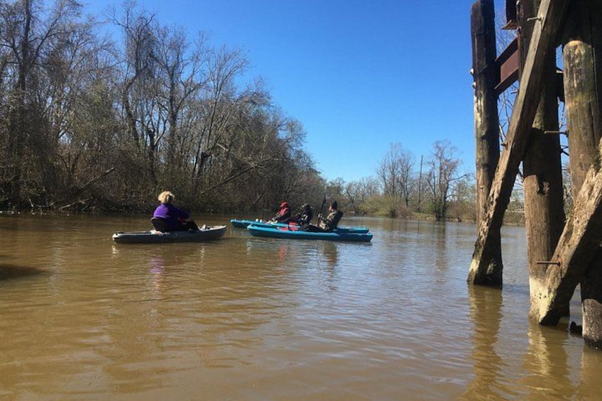 Two canoes on a river with a wooden structure in the background. 3
