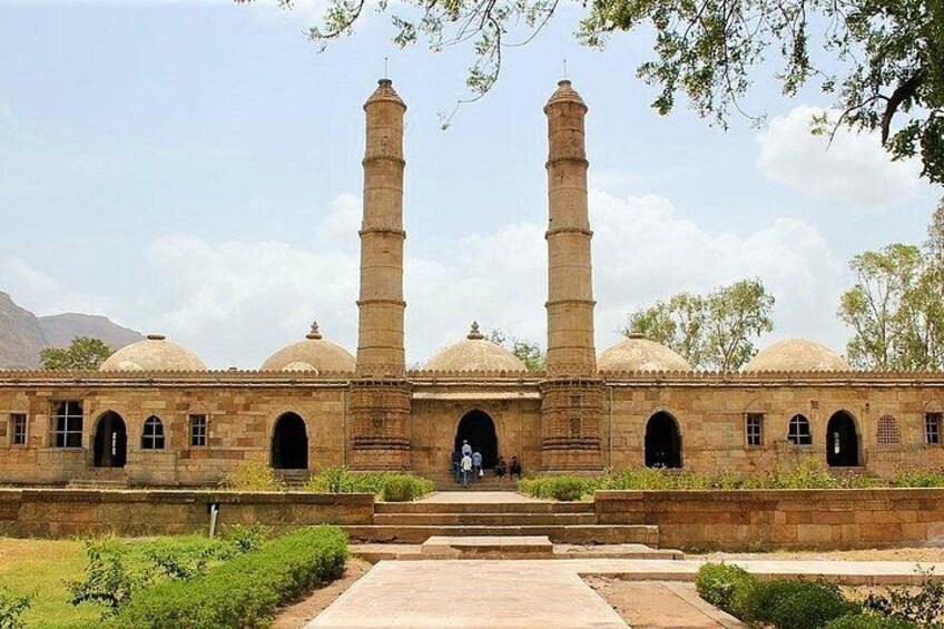 A historical building with two tall minarets, arched windows, and a central entrance. 2