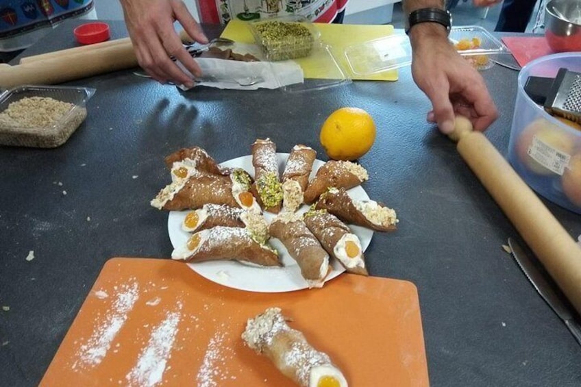 A person preparing food, specifically rolling dough with a rolling pin, and arranging pastries on a plate. 4