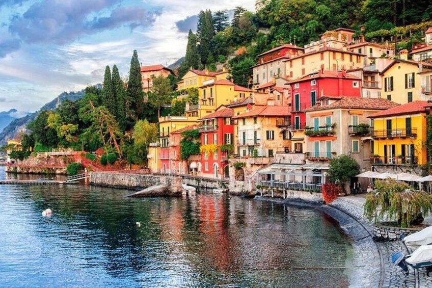 A coastal town with colorful buildings, a calm river, and lush greenery. 3