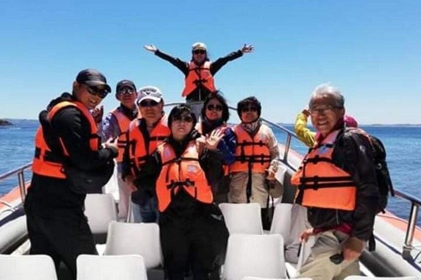 A group of people on a boat wearing life jackets. 1