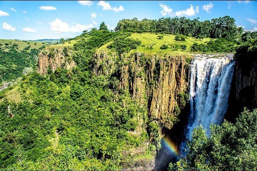 A waterfall cascading down a cliff surrounded by lush greenery. 3