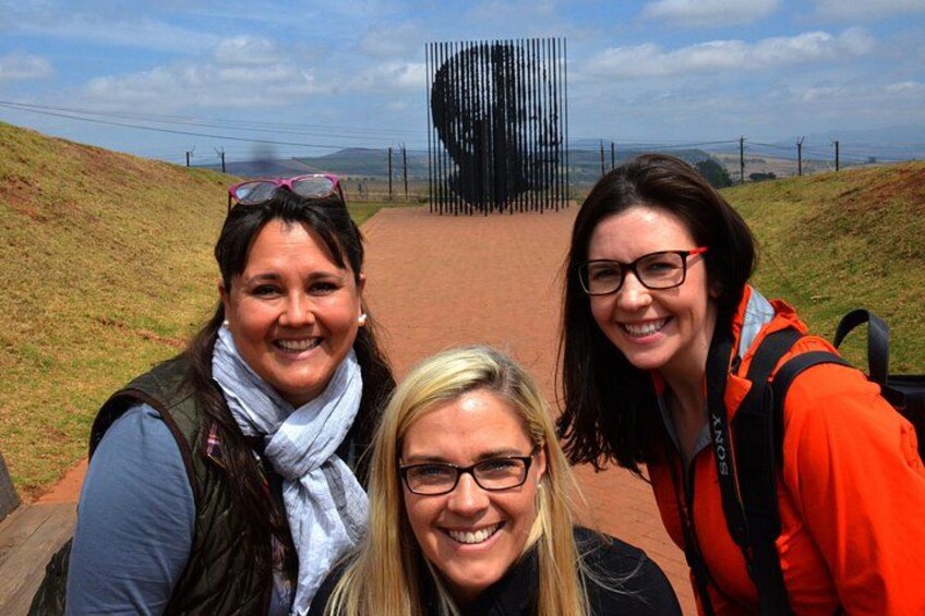 Three people on a path with a large black structure in the background. 4