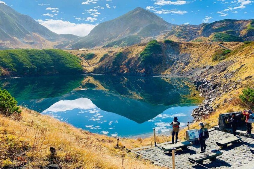 Un paisaje montañoso con un lago tranquilo que refleja el cielo y las colinas circundantes. 2