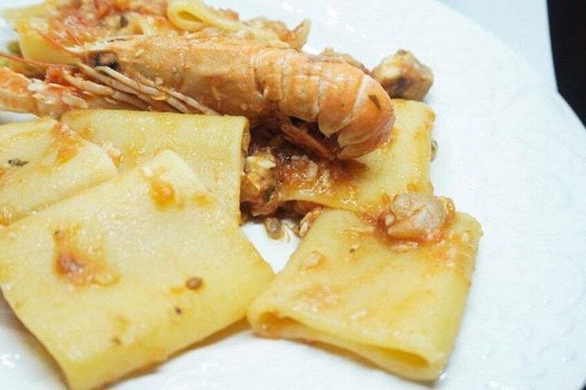 Une assiette de nourriture comprenant des pâtes et une queue de homard. 4