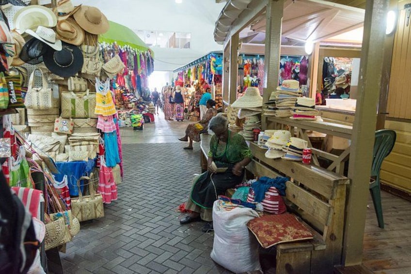 Een markt met diverse kraampjes die hoeden en tassen verkopen. 3