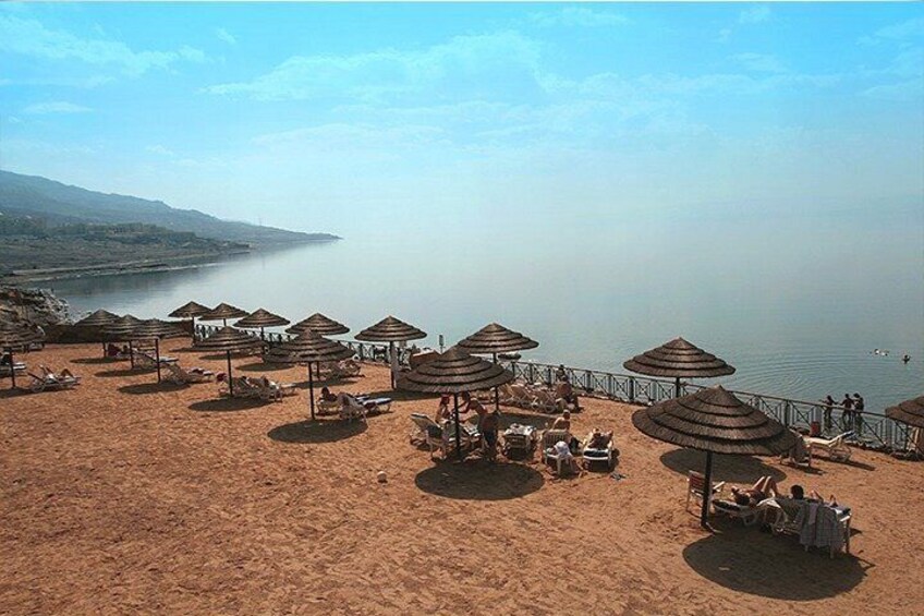 Una playa con sombrillas y sillas reclinables. 1