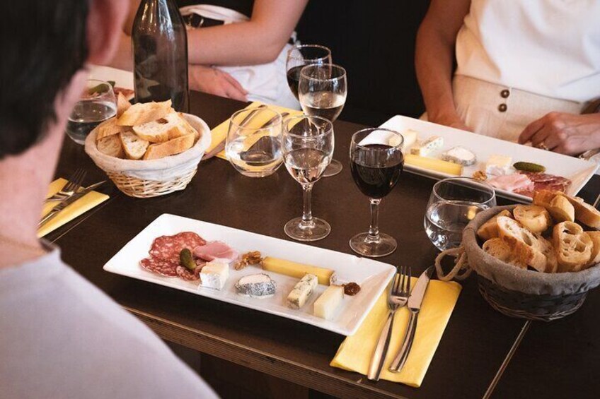 Une table à manger avec différents plats, des verres à vin et une bouteille. 1