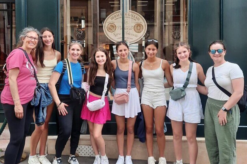 Un groupe de personnes se tient devant un bâtiment orné d’une grande enseigne circulaire. 5