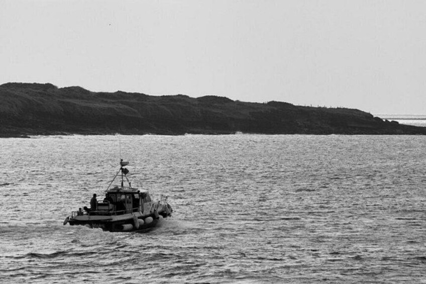 Una barca sull'acqua calma con una costa collinare sullo sfondo. 2