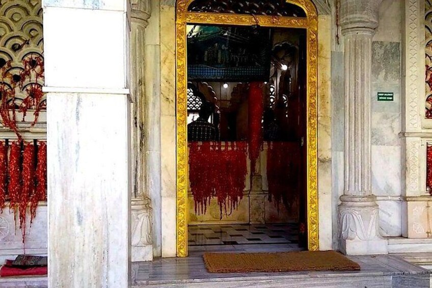 A grand entrance with a golden frame, red drapes, and a doormat. 1
