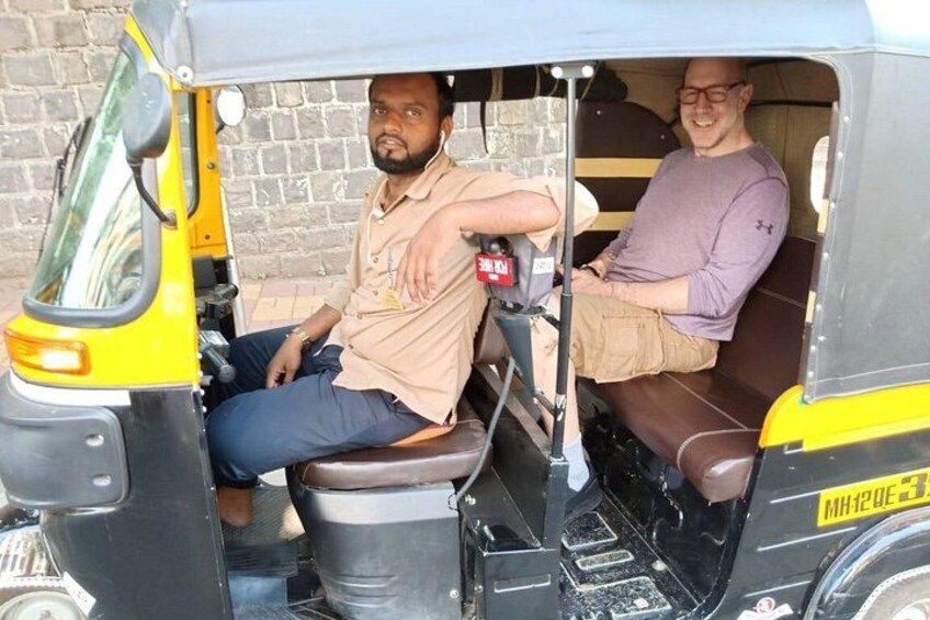 Two people seated inside an auto-rickshaw. 5