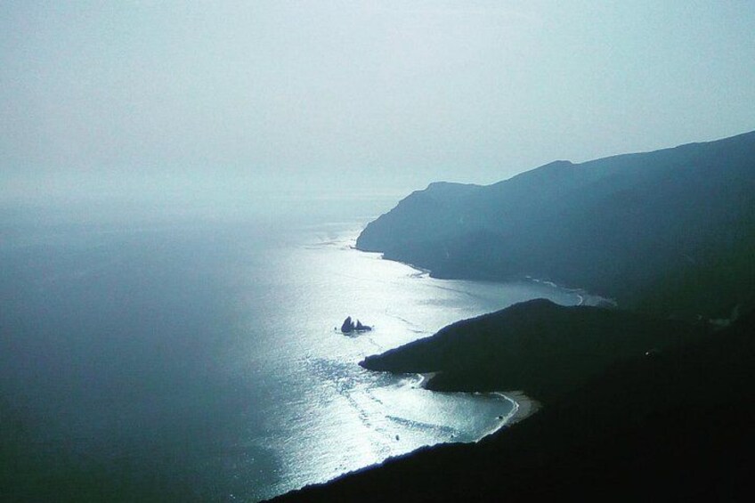 Paesaggio costiero con una nave vicino alla riva, scogliere e mare calmo. 1