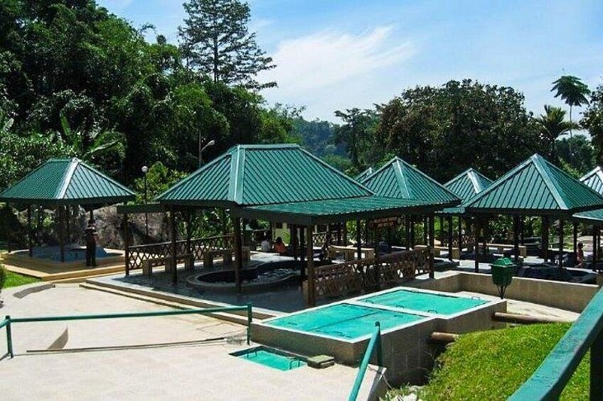 A pool area with green-roofed gazebos and a clear sky. 4