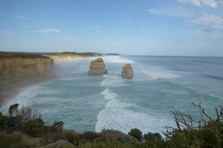 A coastal landscape with cliffs and two prominent rock formations in the sea. 3