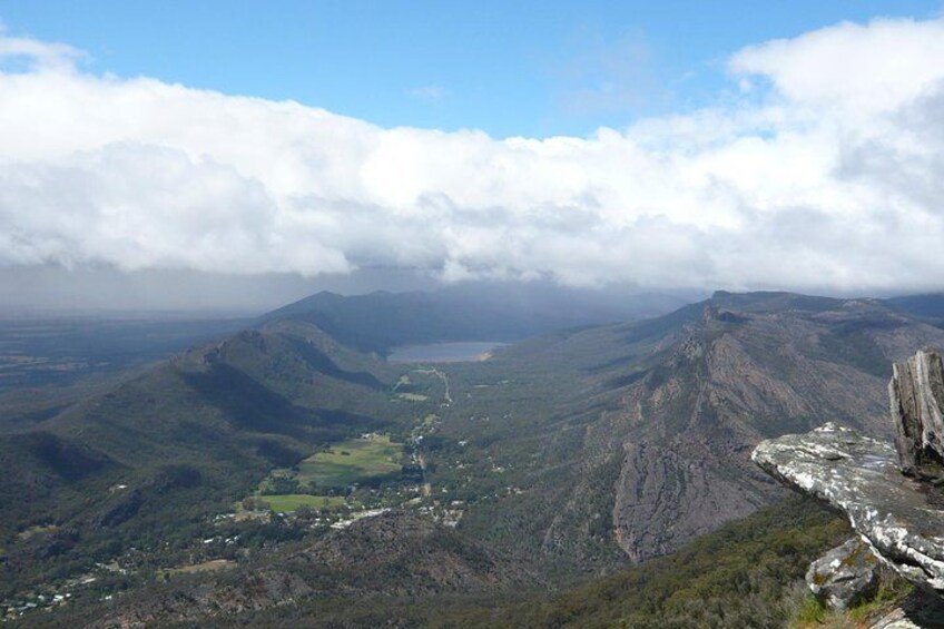 A mountainous landscape with a valley, a river, and a forested area. 1
