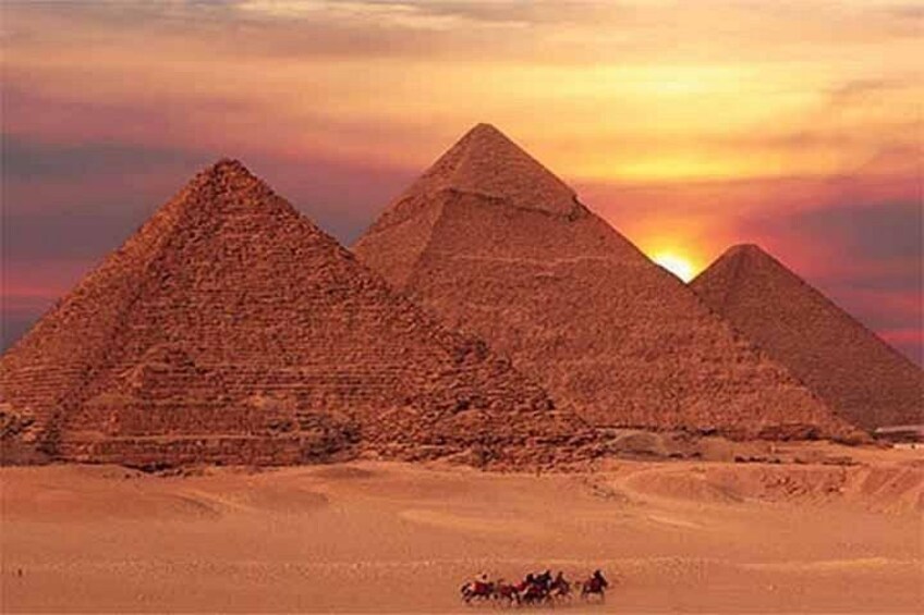 Three pyramids in a desert landscape with a sunset in the background. 5