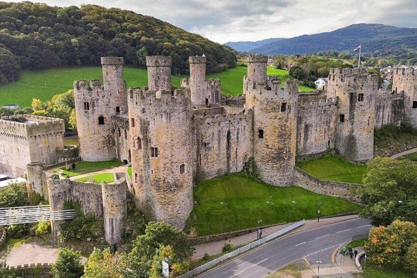 Un castello storico circondato da campi verdi e una strada. 2