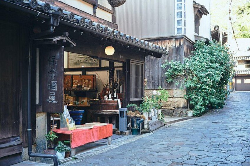 A traditional Japanese building with a wooden facade, a red table outside, and potted plants. 2