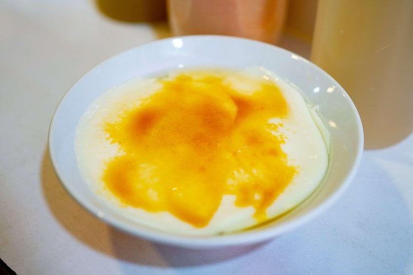 En hvid skål med et gult indhold, sandsynligvis en dessert eller en ret. 3