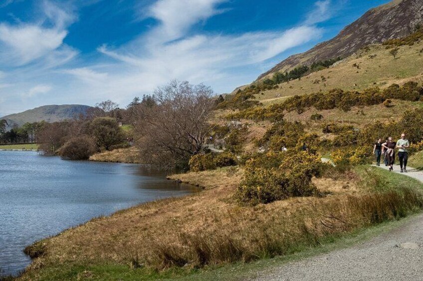 A river, a group of people walking, and a hilly landscape. 5