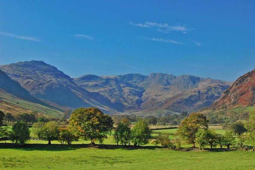 A mountainous landscape with green fields and trees. 3
