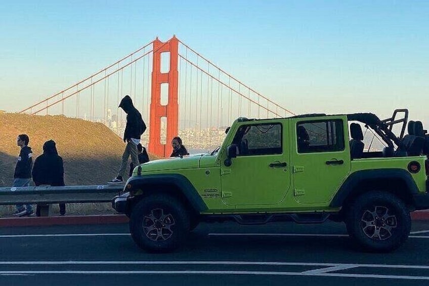 Et gult terrængående køretøj på en bro med Golden Gate Bridge i baggrunden. 3