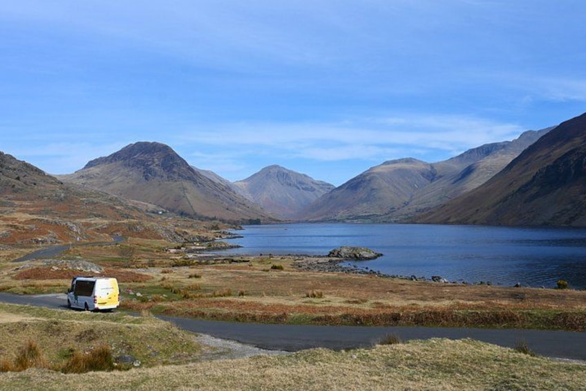 A camper van parked near a lake surrounded by mountains. 5