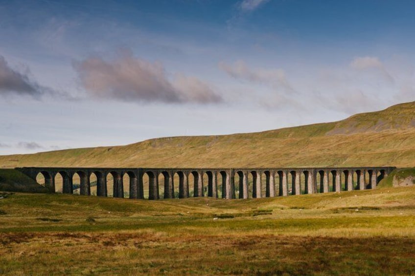 Eine lange Viadukt, der sich durch eine hügelige Landschaft zieht. 1