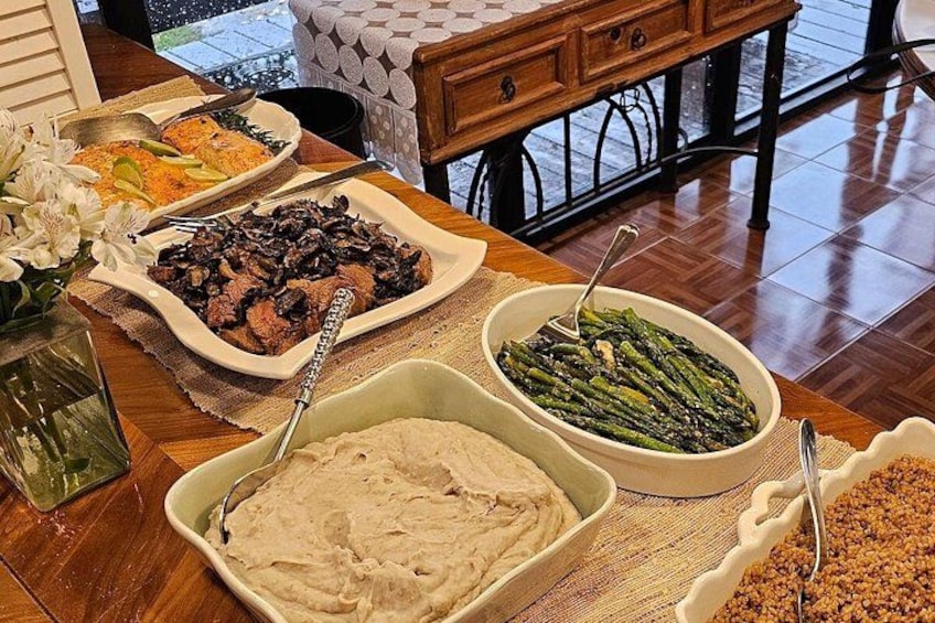 A dining table with various dishes including a bowl of mashed potatoes, a plate of meat, and a bowl of asparagus. 4