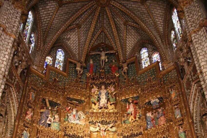 An ornate cathedral interior with a high vaulted ceiling, stained glass windows, and detailed religious artwork. 4