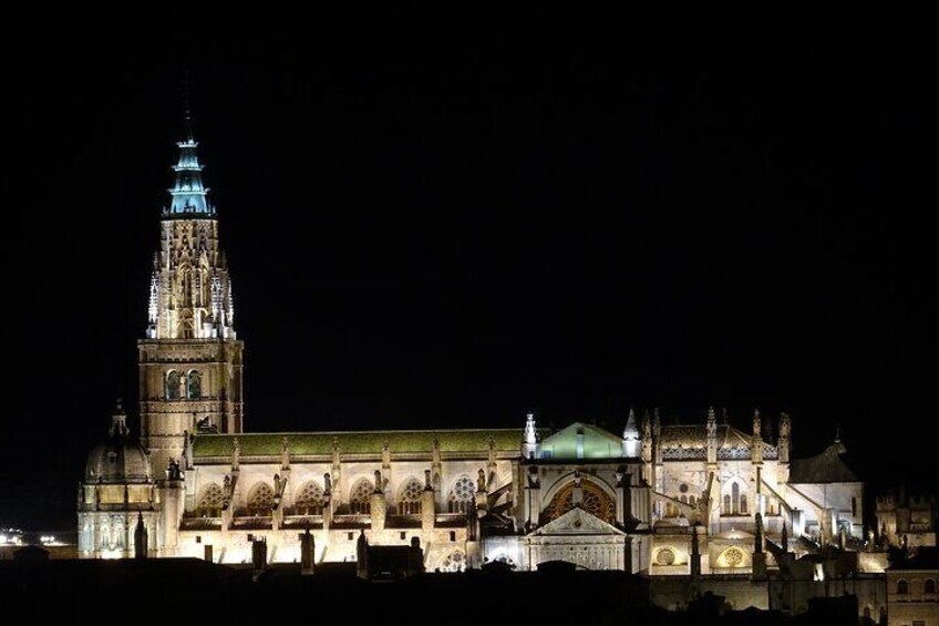 A large illuminated cathedral with a prominent tower and detailed facade at night. 5