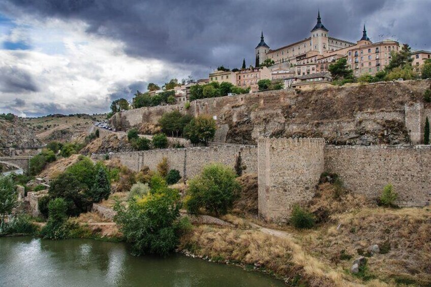 A historic castle on a hill with a river in the foreground. 3