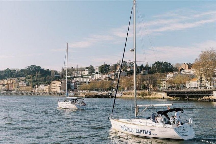 A harbor with sailboats, a bridge, and buildings in the background. 2