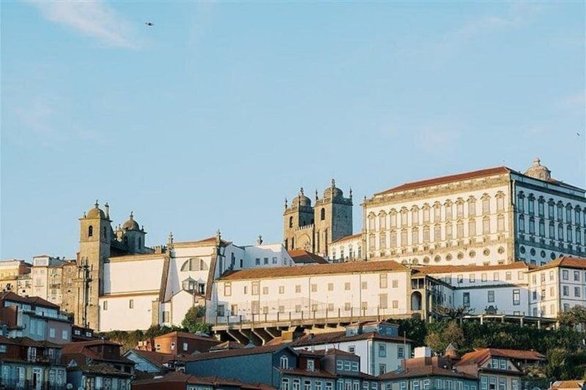 A cityscape with historic buildings, including a prominent white structure with columns and a clock tower. 4