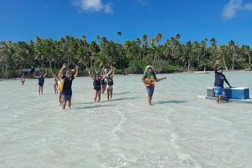 Un grupo de personas en una playa con palmeras al fondo. 4