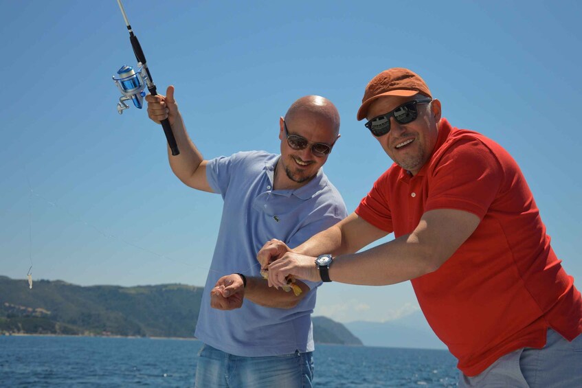 Two people fishing by the sea. 1