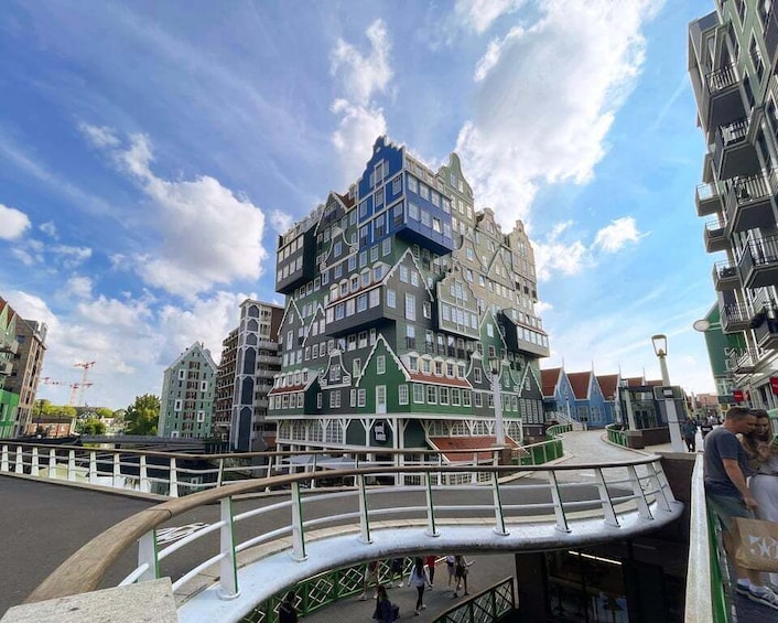 A multi-story building with a unique architectural design, a pedestrian bridge, and a clear sky. 5