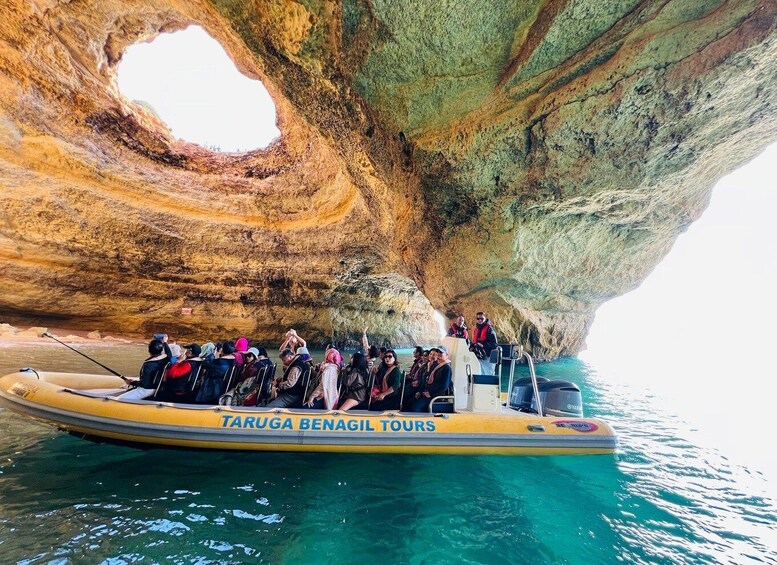 A boat with tourists on a tour near a large rock formation. 2