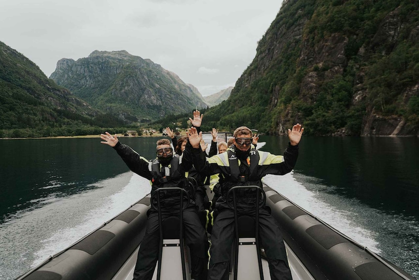A group of people on a boat in a river surrounded by mountains. 2