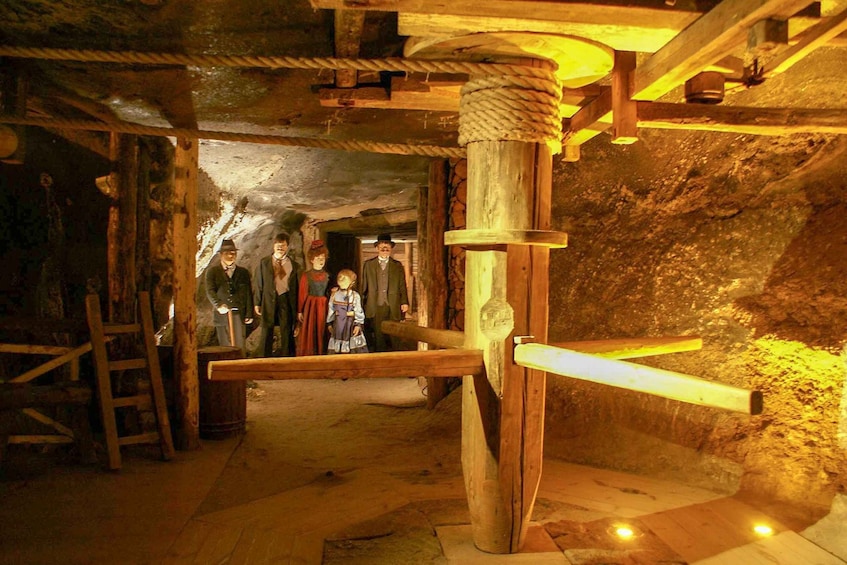 A historical mining exhibit with wooden structures and figures. 5